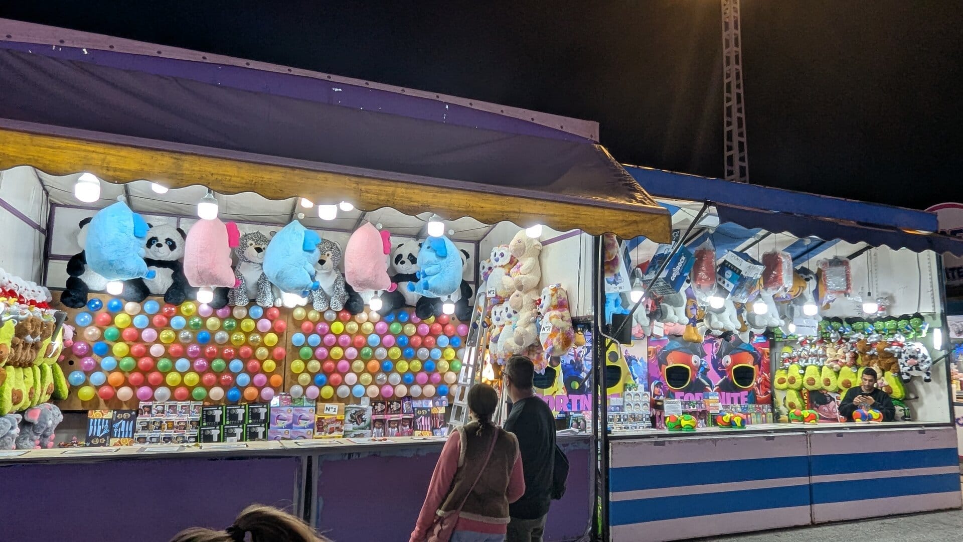 Casetas de premios con pared de globos, ositos de peluche gigantes y expositores de juguetes